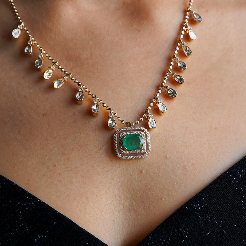 Glimmer Glitz necklace with emerald teardrops and polki diamonds worn by model