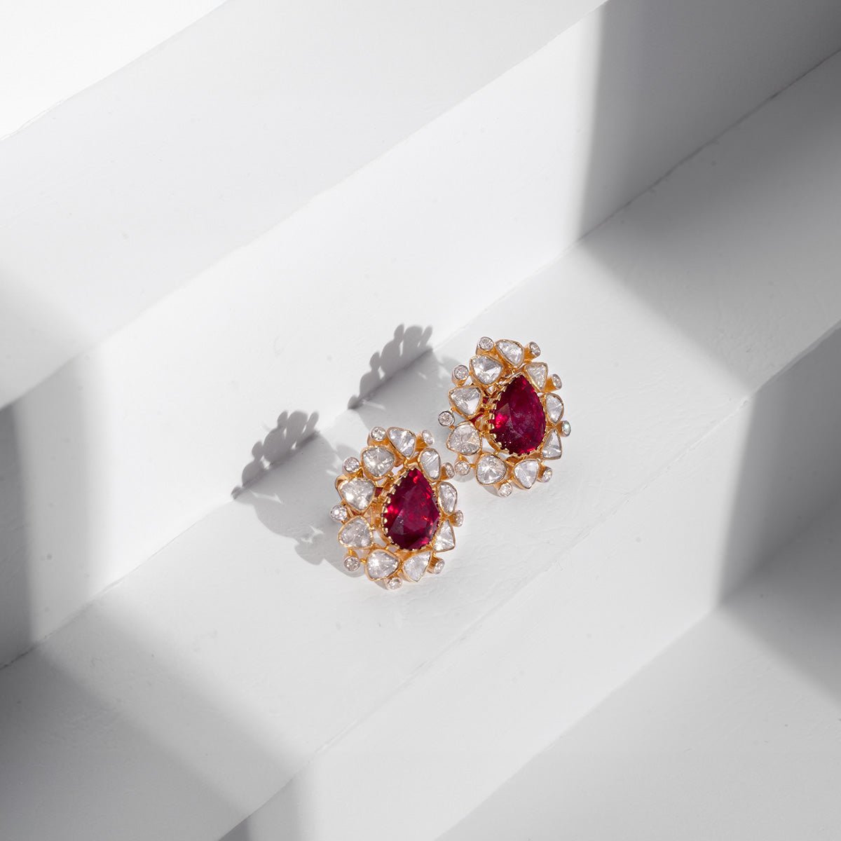 Jewelry-only image of Imperial earrings with vivid rubies and detailed uncut diamond border.