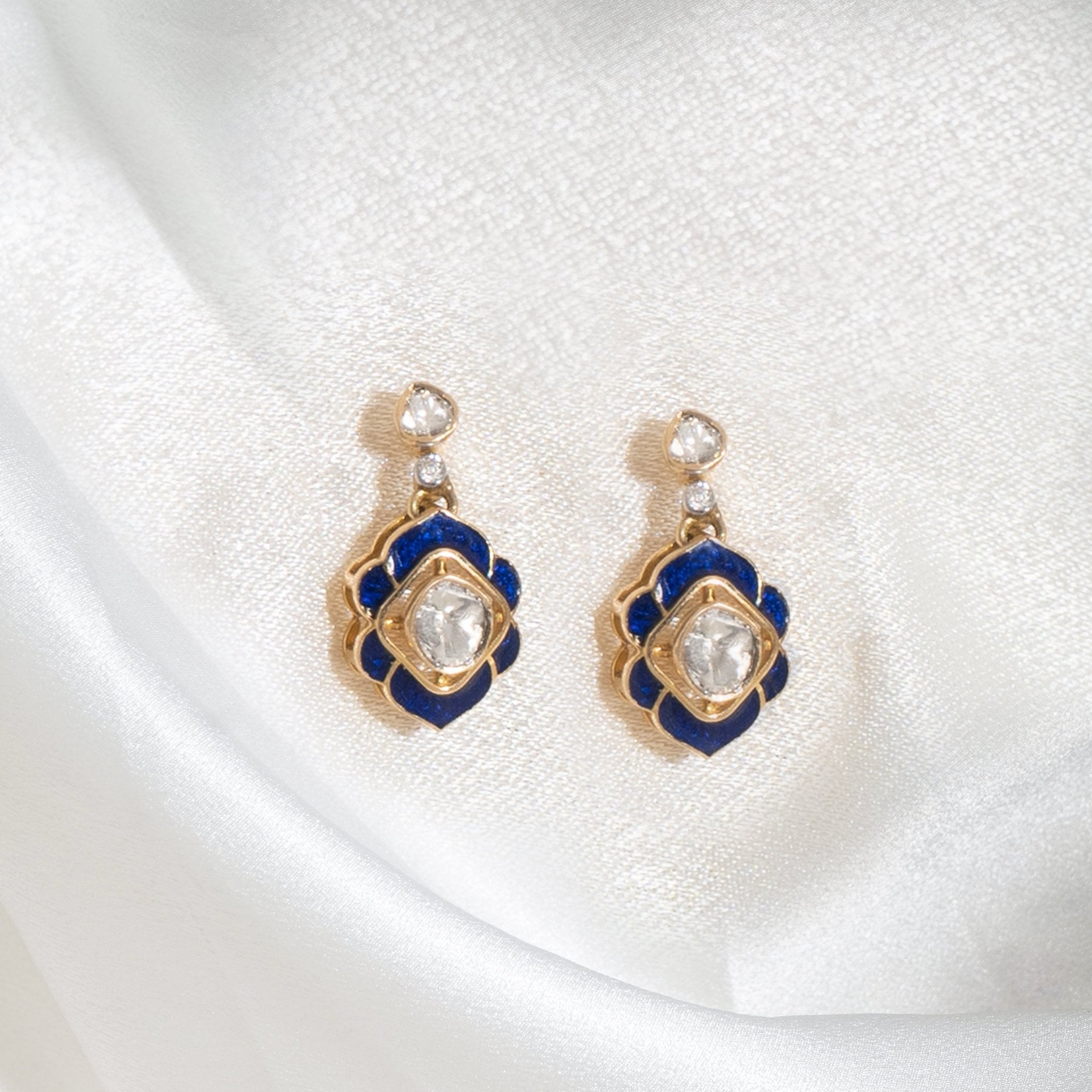 Crescent moon earrings with polki and blue gemstones.