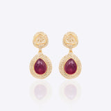 Oval ruby and Polki diamond drop earrings in 14K gold with a double-halo design.