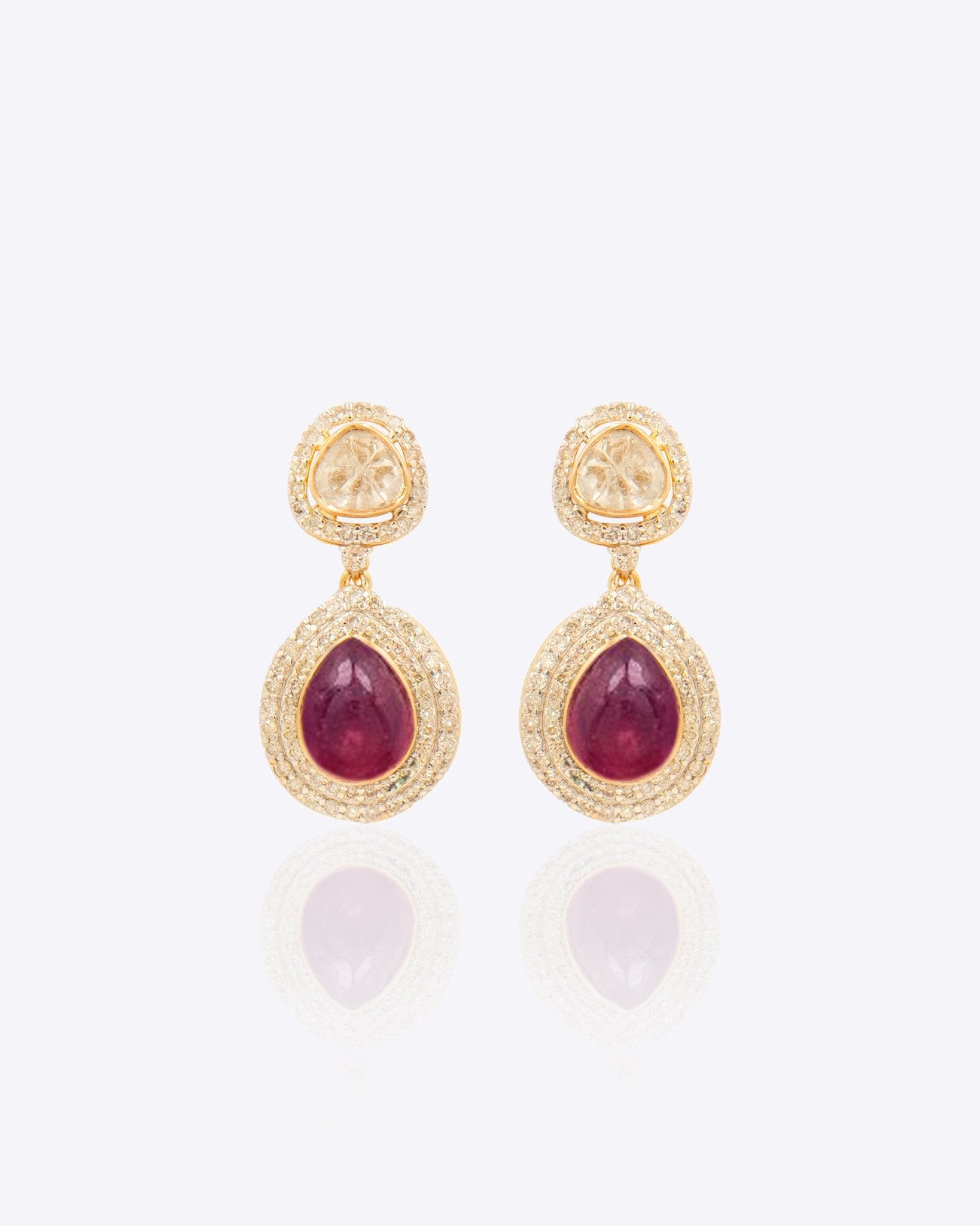 Oval ruby and Polki diamond drop earrings in 14K gold with a double-halo design.