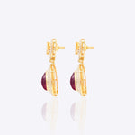 Oval ruby and Polki diamond drop earrings in 14K gold with a double-halo design.