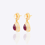 Oval ruby and Polki diamond drop earrings in 14K gold with a double-halo design.