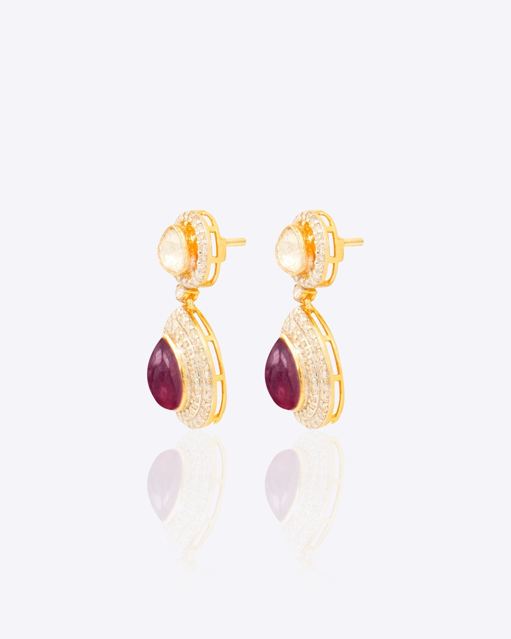 Oval ruby and Polki diamond drop earrings in 14K gold with a double-halo design.