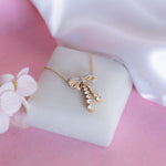 14kt gold necklace with delicate bow design and cascading drops
