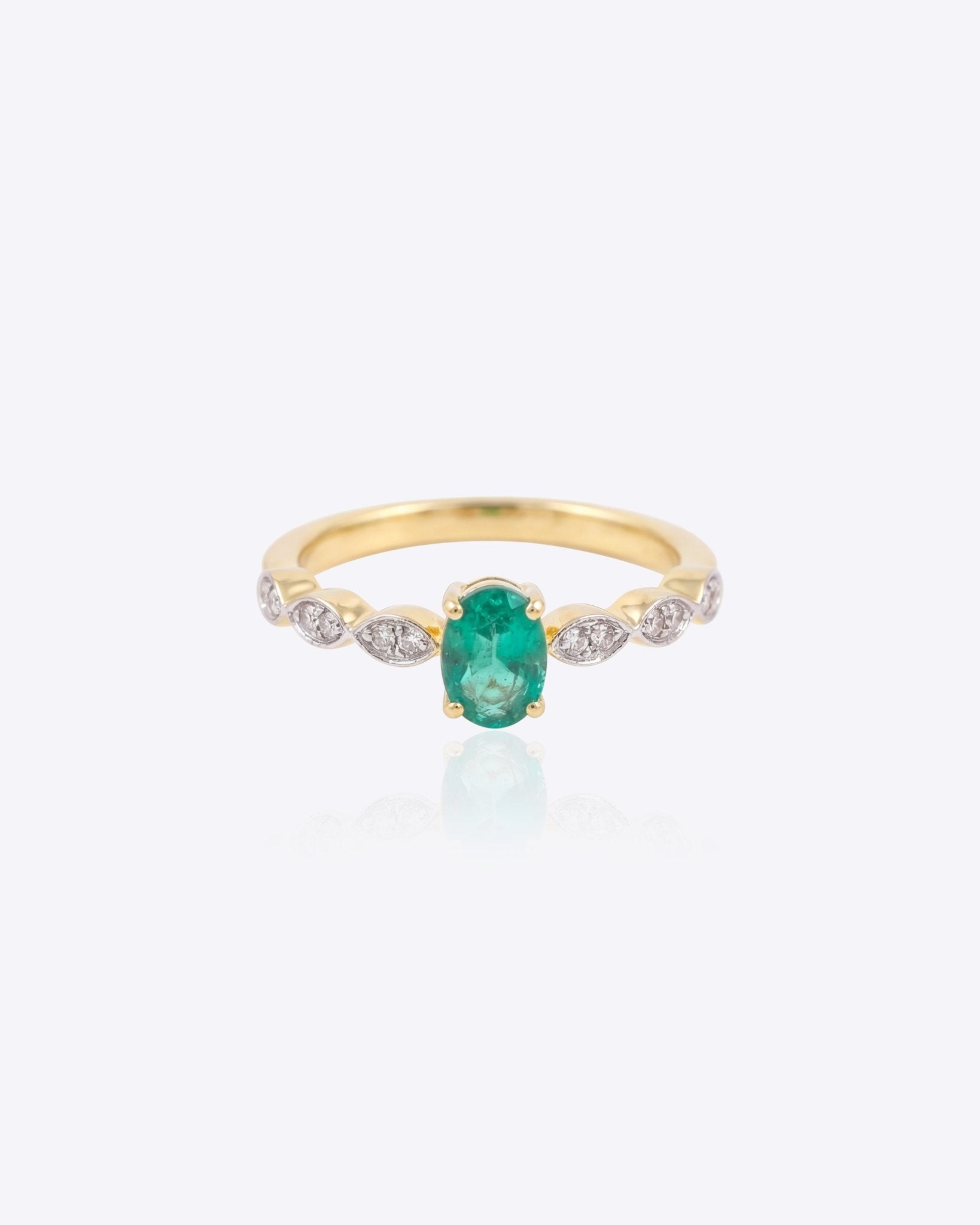 14K gold ring with a vivid emerald framed by diamonds