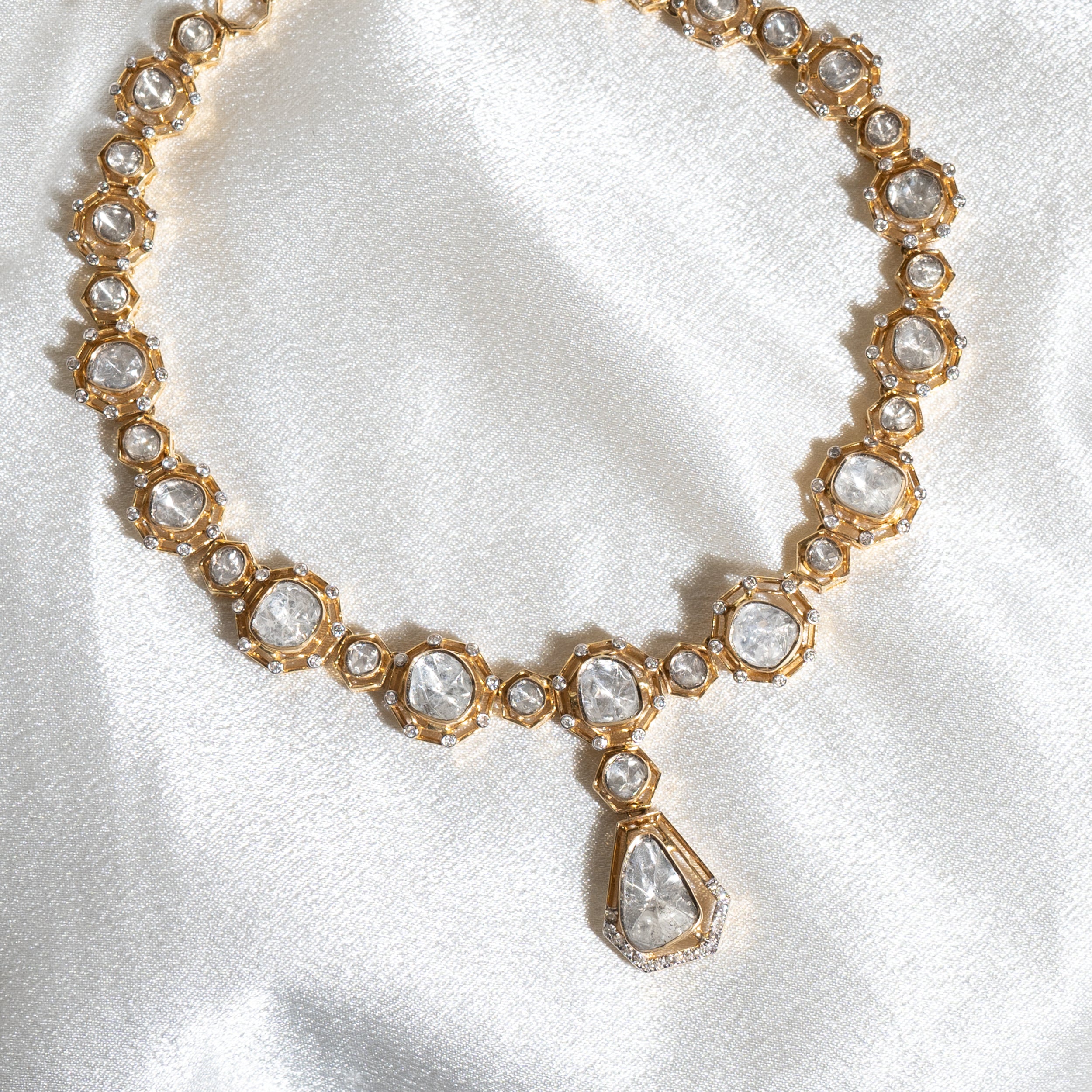 Golden knot necklace with diamond polkis, a classy and elegant accessory.