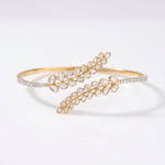 14K gold palm bracelet with a feather-inspired design and Polki accents