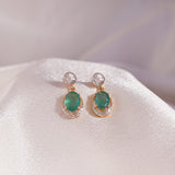 18k gold earrings with a polki and diamond halo, featuring a suspended emerald