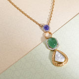 Pendant with radiant sapphire, lustrous emerald, and dazzling diamond polki in a golden cast.