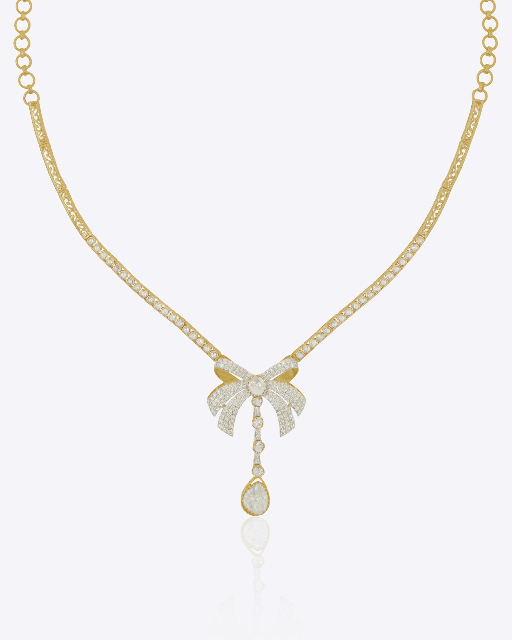 14kt gold choker necklace featuring intricate jali work and a central three-dimensional folded bow design.