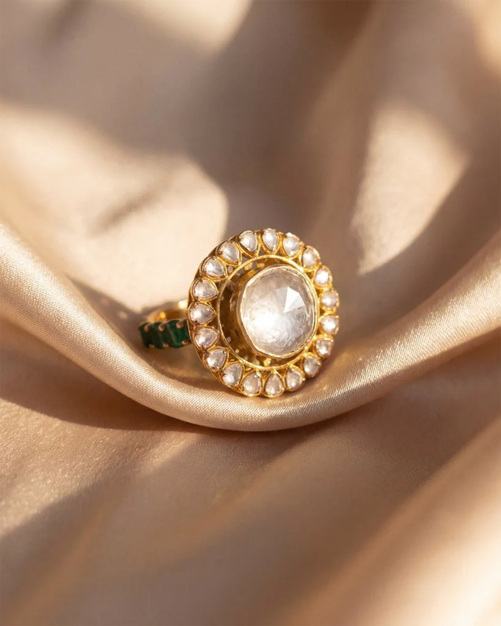 Sunburst Polki Ring in 14K gold with a central Polki halo of Zambian emeralds.