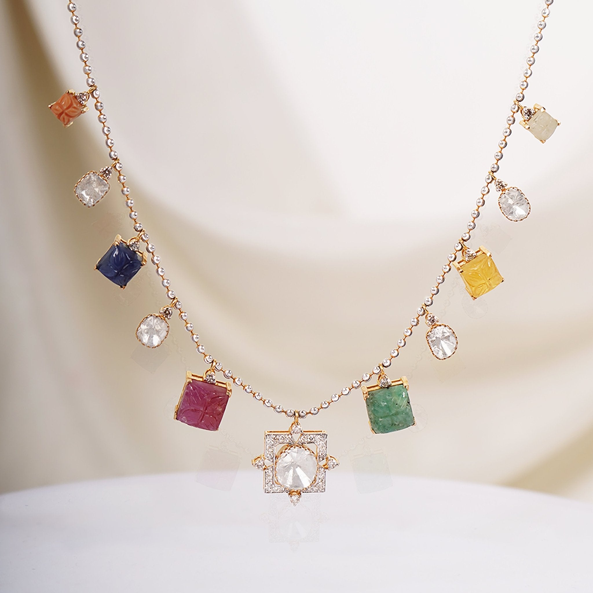A stunning necklace with polki diamonds on a gold string, adorned with square-shaped gemstones.