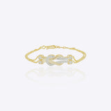 14K gold bracelet with a delicate chain and elegant knot centerpiece creating a minimal and sophisticated look.