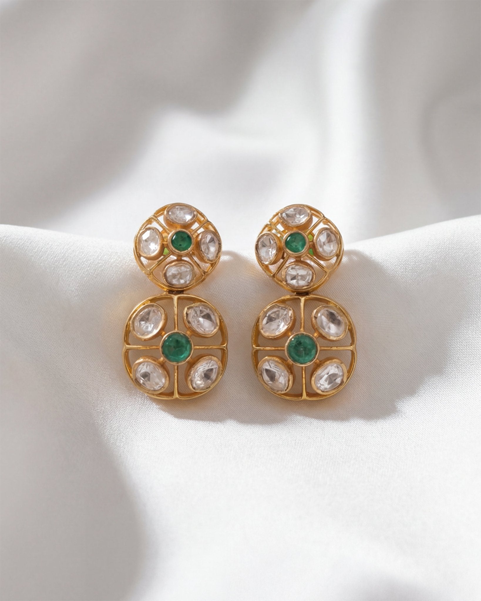 18K gold earrings with a central Polki diamond surrounded by vibrant emeralds.