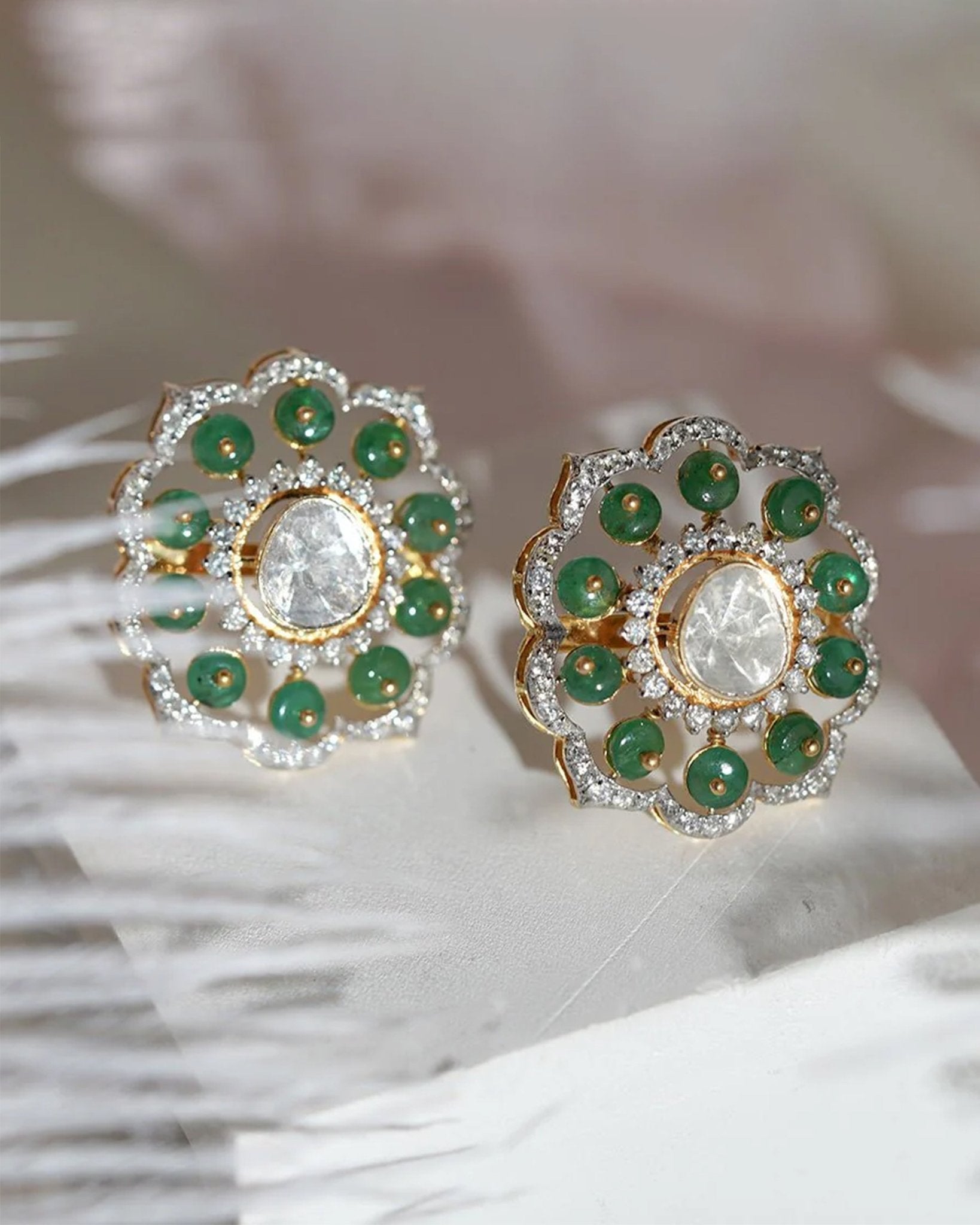 14K gold floral drop earrings set with Polki diamonds and emerald accents.