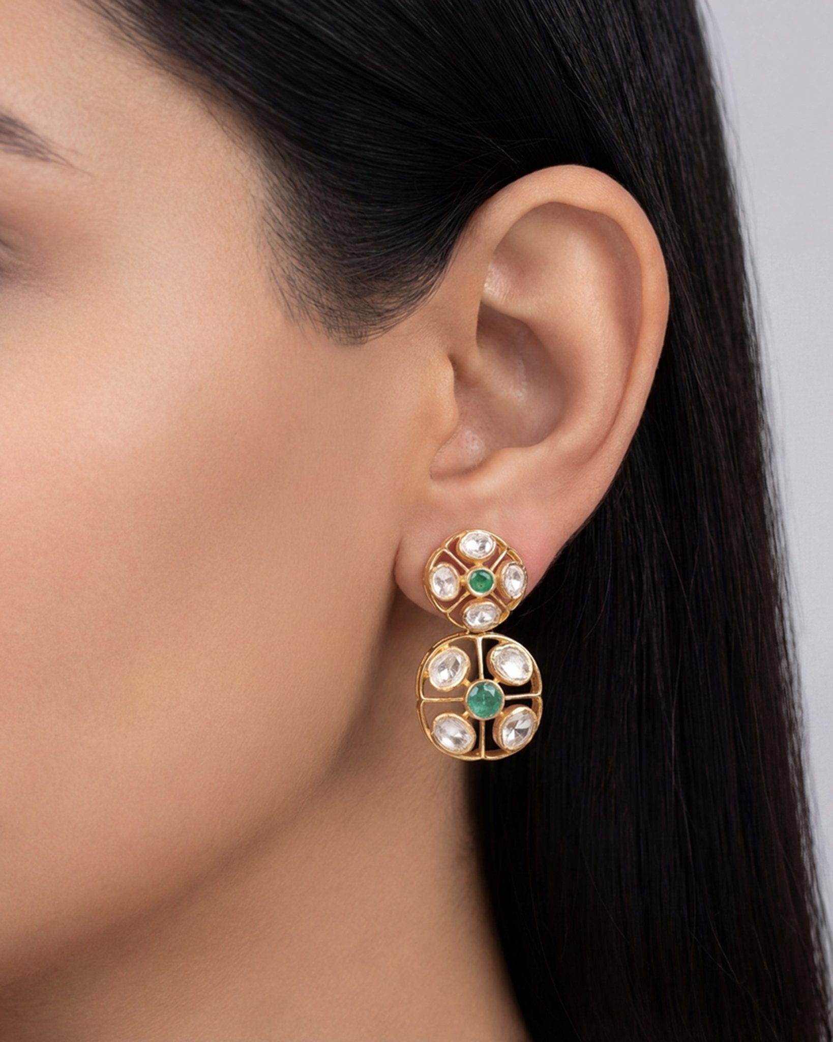 18K gold earrings with a central Polki diamond surrounded by vibrant emeralds.