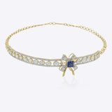 The Bowline Choker in 14K gold with a bow motif, blue stone, Polki, and diamonds.