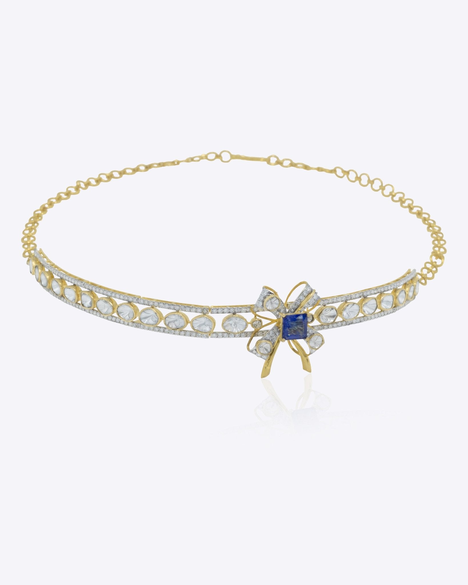 The Bowline Choker in 14K gold with a bow motif, blue stone, Polki, and diamonds.