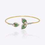 14kt gold Petal Drift Bangle with delicate petal motifs and green accents.