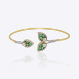 14kt gold Petal Drift Bangle with delicate petal motifs and green accents.
