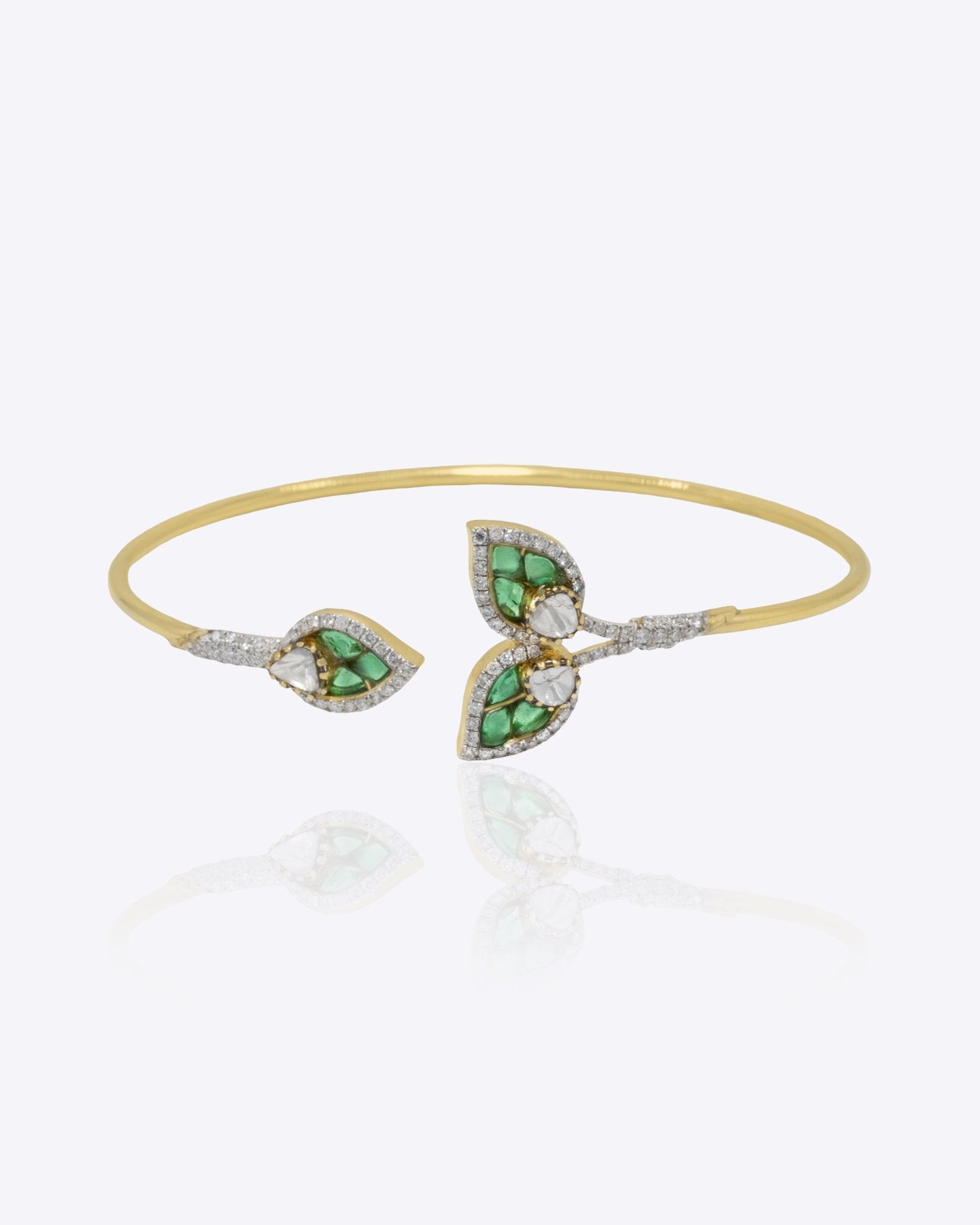 14kt gold Petal Drift Bangle with delicate petal motifs and green accents.