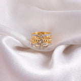 14K gold plated ring with diamond-lined layered bands and a sculpted bow centerpiece.