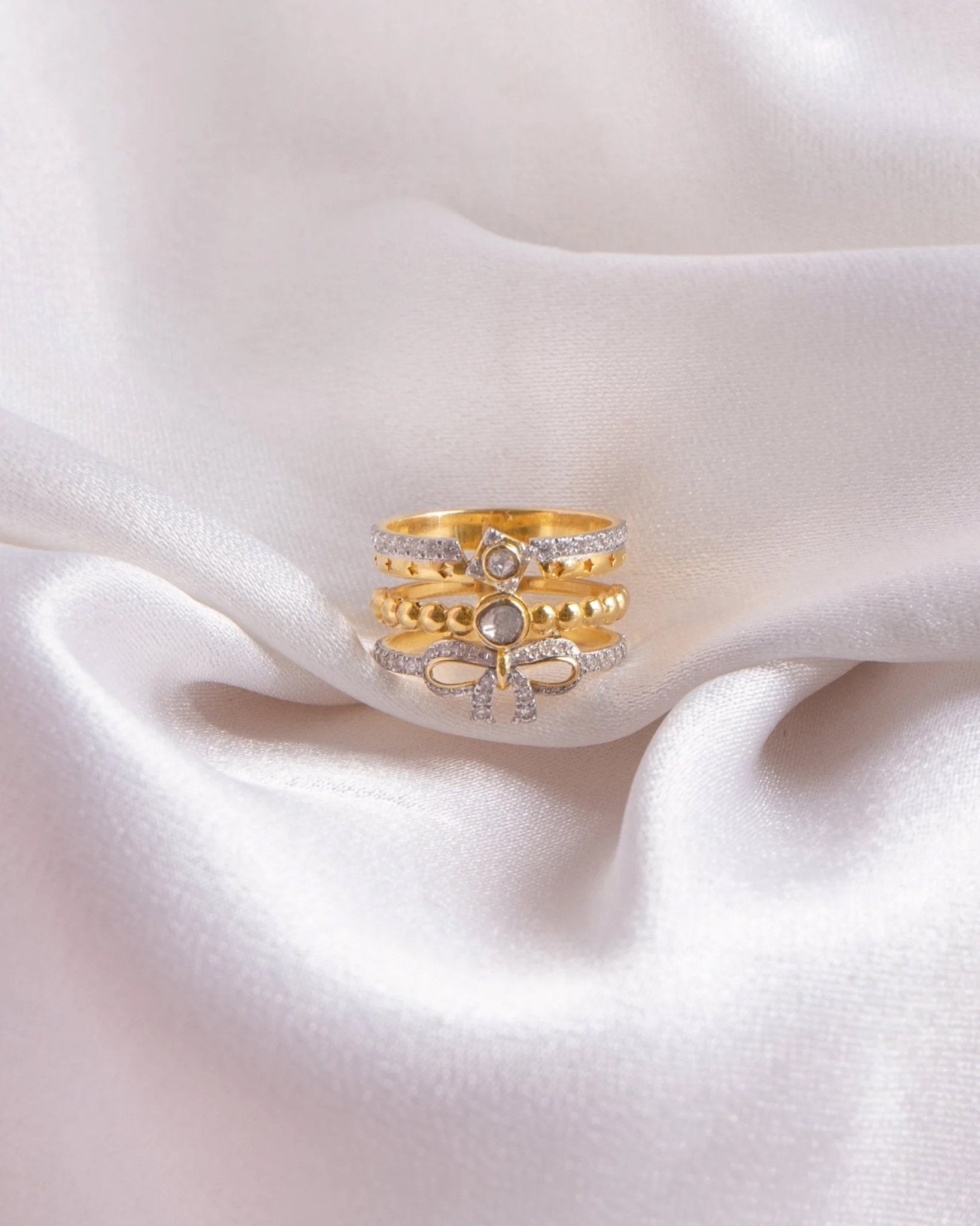 14K gold plated ring with diamond-lined layered bands and a sculpted bow centerpiece.