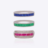 18K white gold stackable ring trio with vivid blue, crimson, and green stones.