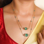 14K gold necklace with emerald-green gemstones and ruby accents
