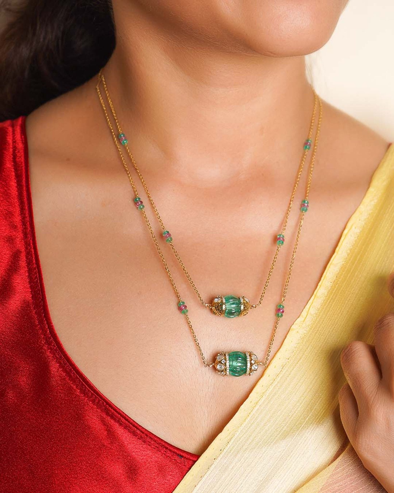 14K gold necklace with emerald-green gemstones and ruby accents