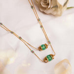 14K gold necklace with emerald-green gemstones and ruby accents