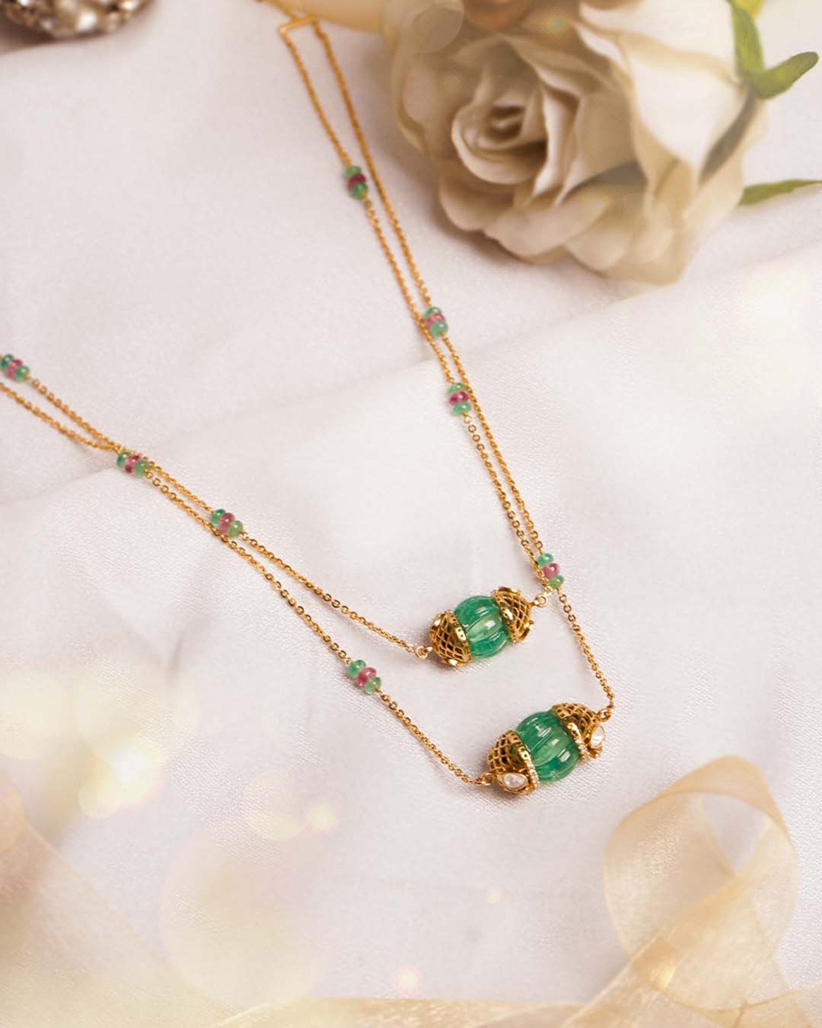 14K gold necklace with emerald-green gemstones and ruby accents