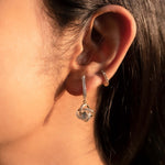 14K gold woven-texture knot earrings with a central luminous stone.
