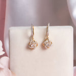 14K gold woven-texture knot earrings with a central luminous stone.