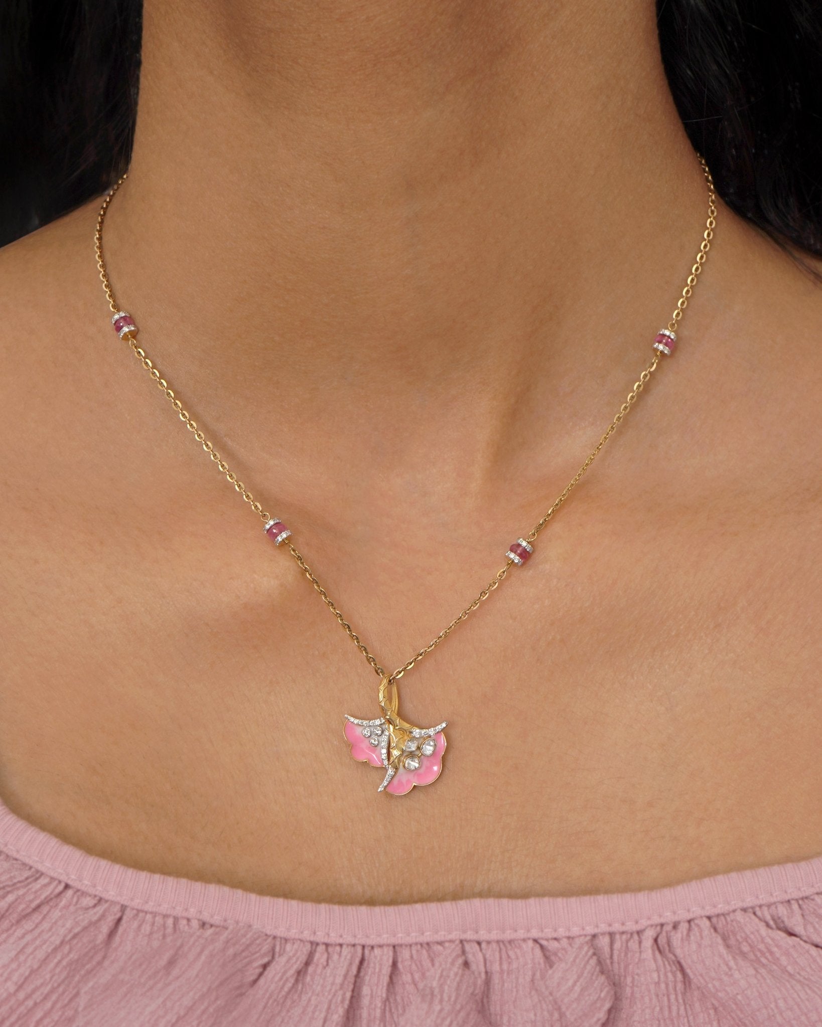 9K gold pendant with a blush petal silhouette and soft pink accents.