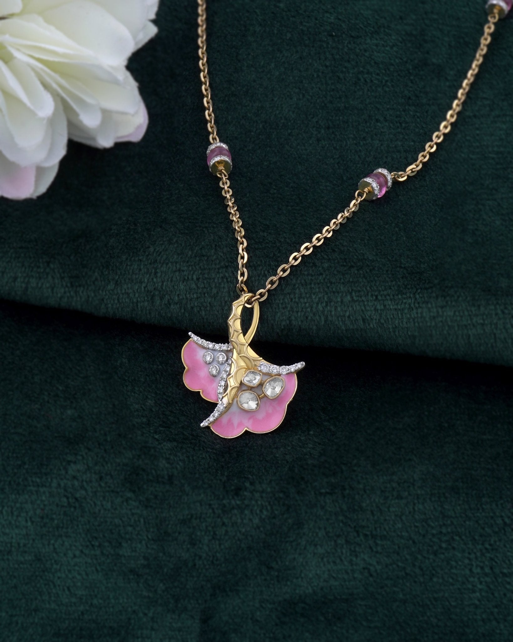 9K gold pendant with a blush petal silhouette and soft pink accents.