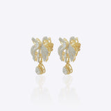 14K gold earrings with a 3D folded bow design and cascading stones.