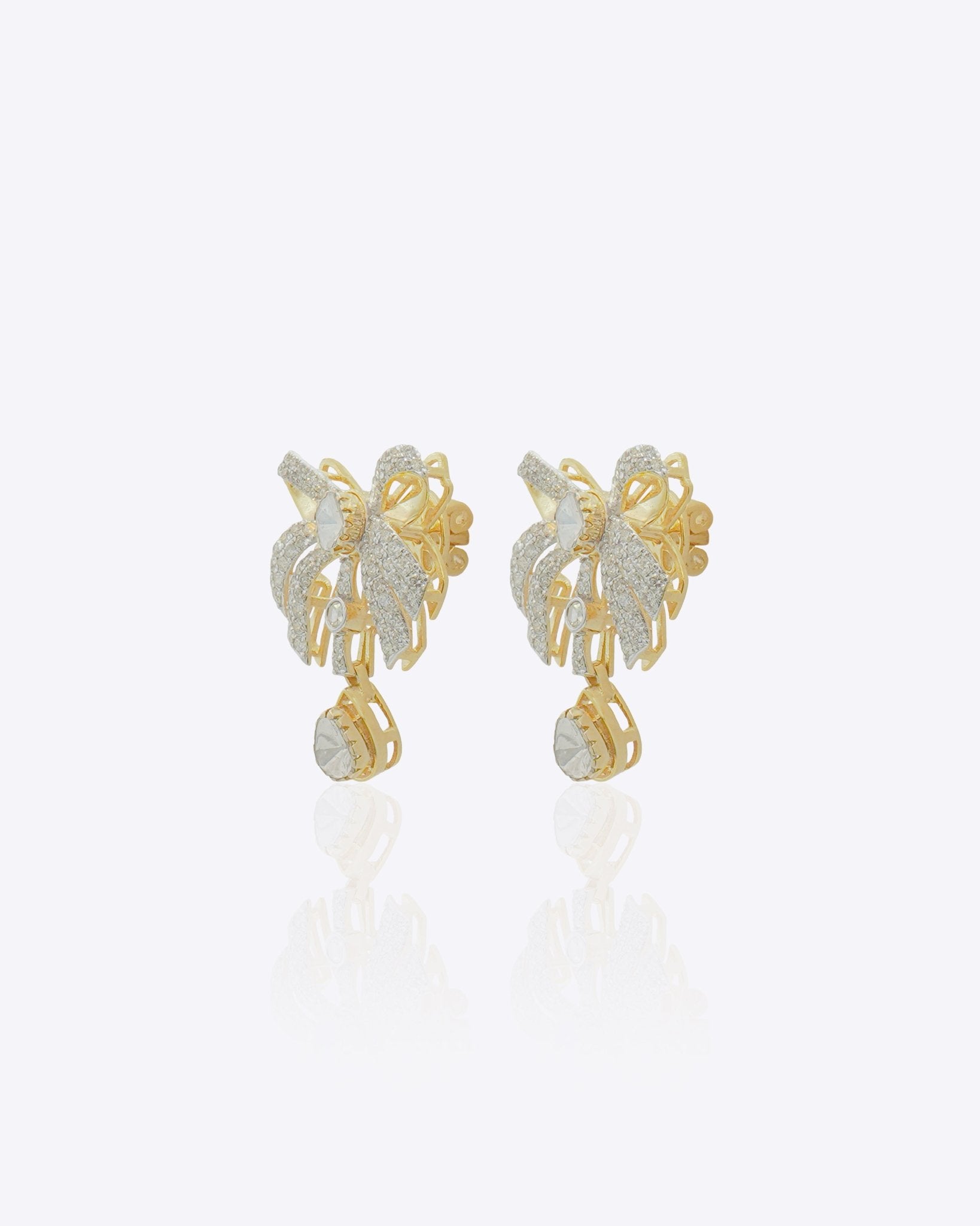 14K gold earrings with a 3D folded bow design and cascading stones.