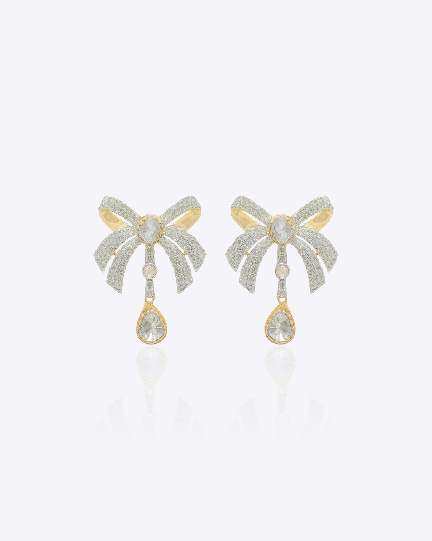 14K gold earrings with a 3D folded bow design and cascading stones.