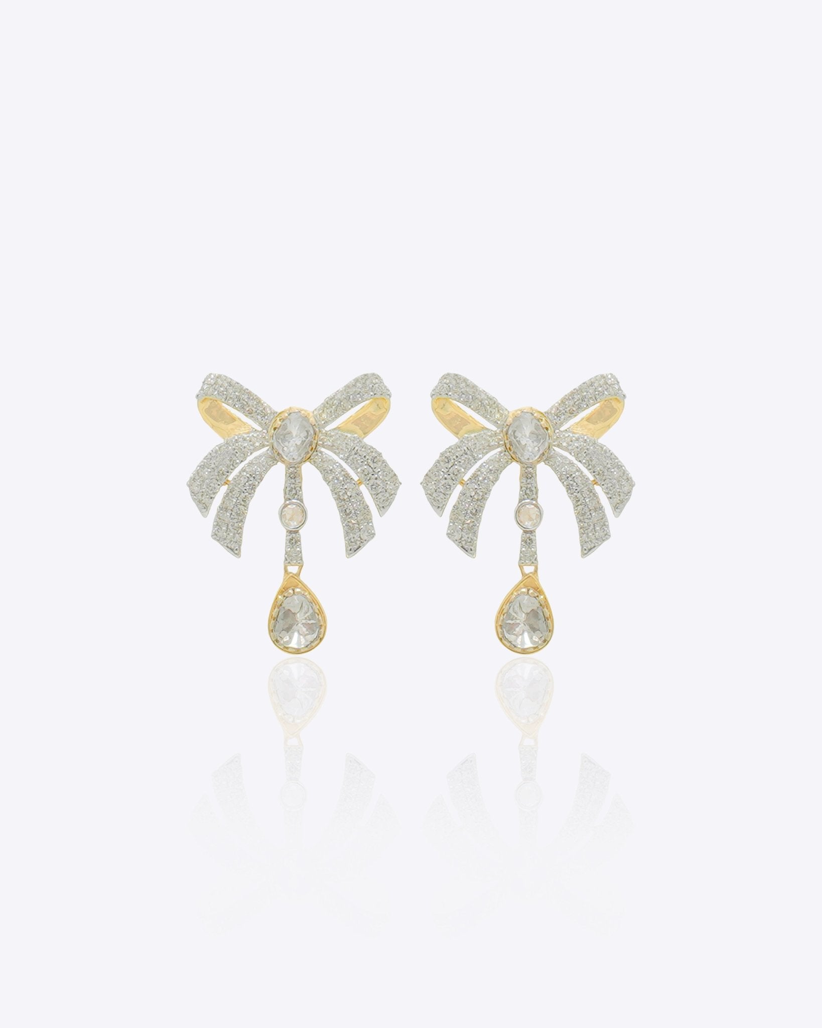14kt gold earrings featuring a three-dimensional folded bow design with delicate cascading stones for movement.