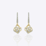 14K gold woven-texture knot earrings with a central luminous stone.