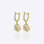 14K gold woven-texture knot earrings with a central luminous stone.
