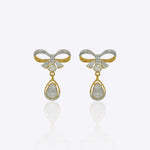 14kt gold earrings featuring a delicate bow motif with small stones and a hanging pear-shaped gemstone droplet.