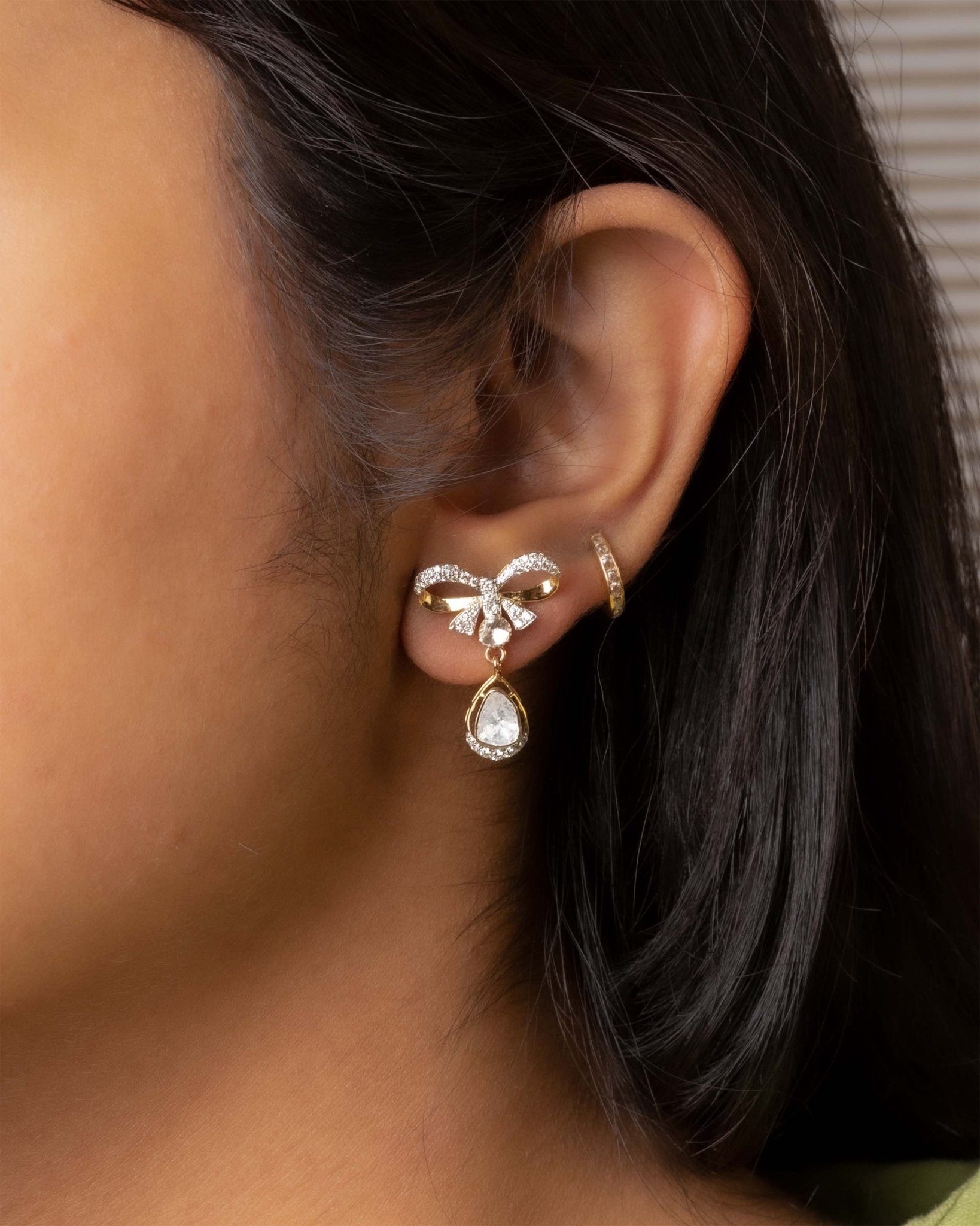 14K gold bow-motif drop earrings with a pear-shaped stone.