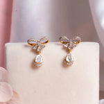 14K gold bow-motif drop earrings with a pear-shaped stone.