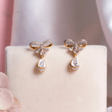 14K gold bow-motif drop earrings with a pear-shaped stone.