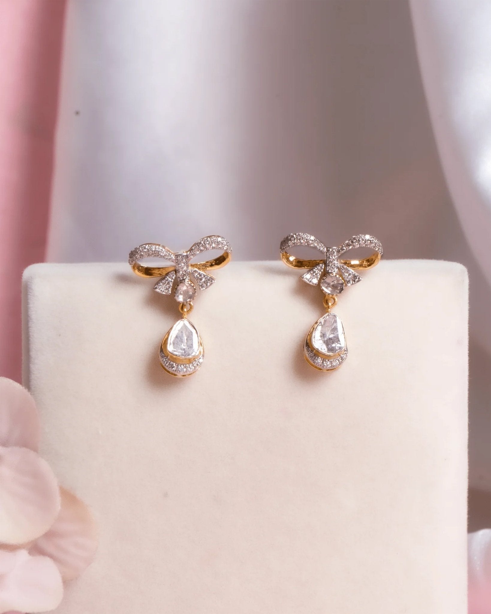 14K gold bow-motif drop earrings with a pear-shaped stone.
