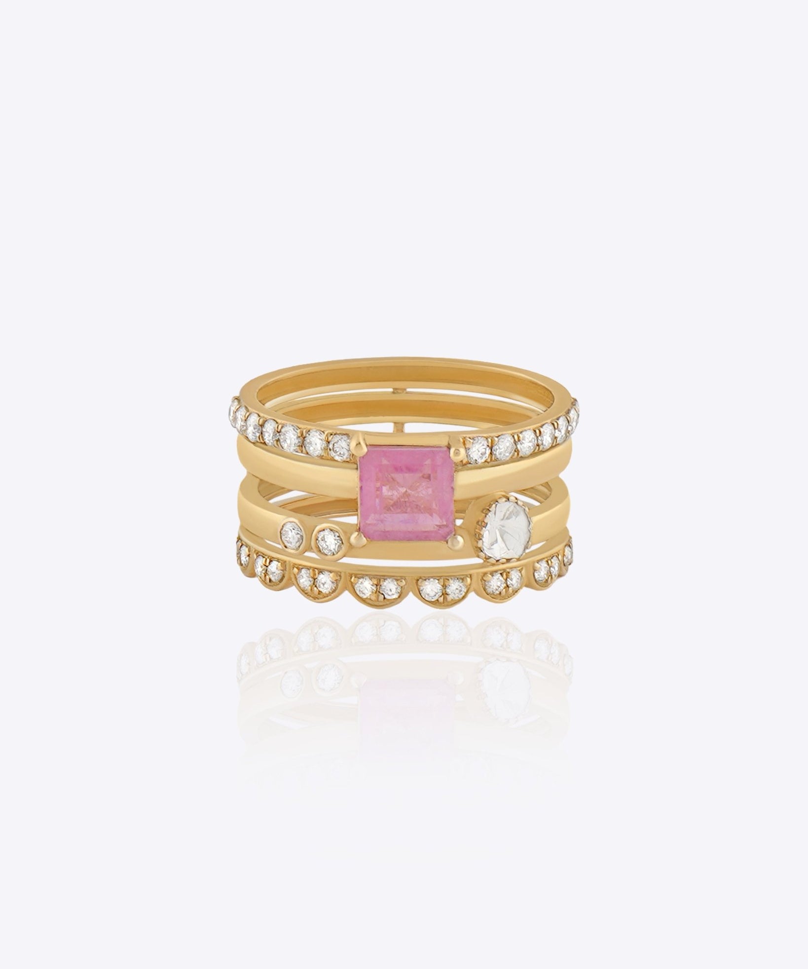 Featuring a multi-layered gold band with a pink center stone and Polki detailing.