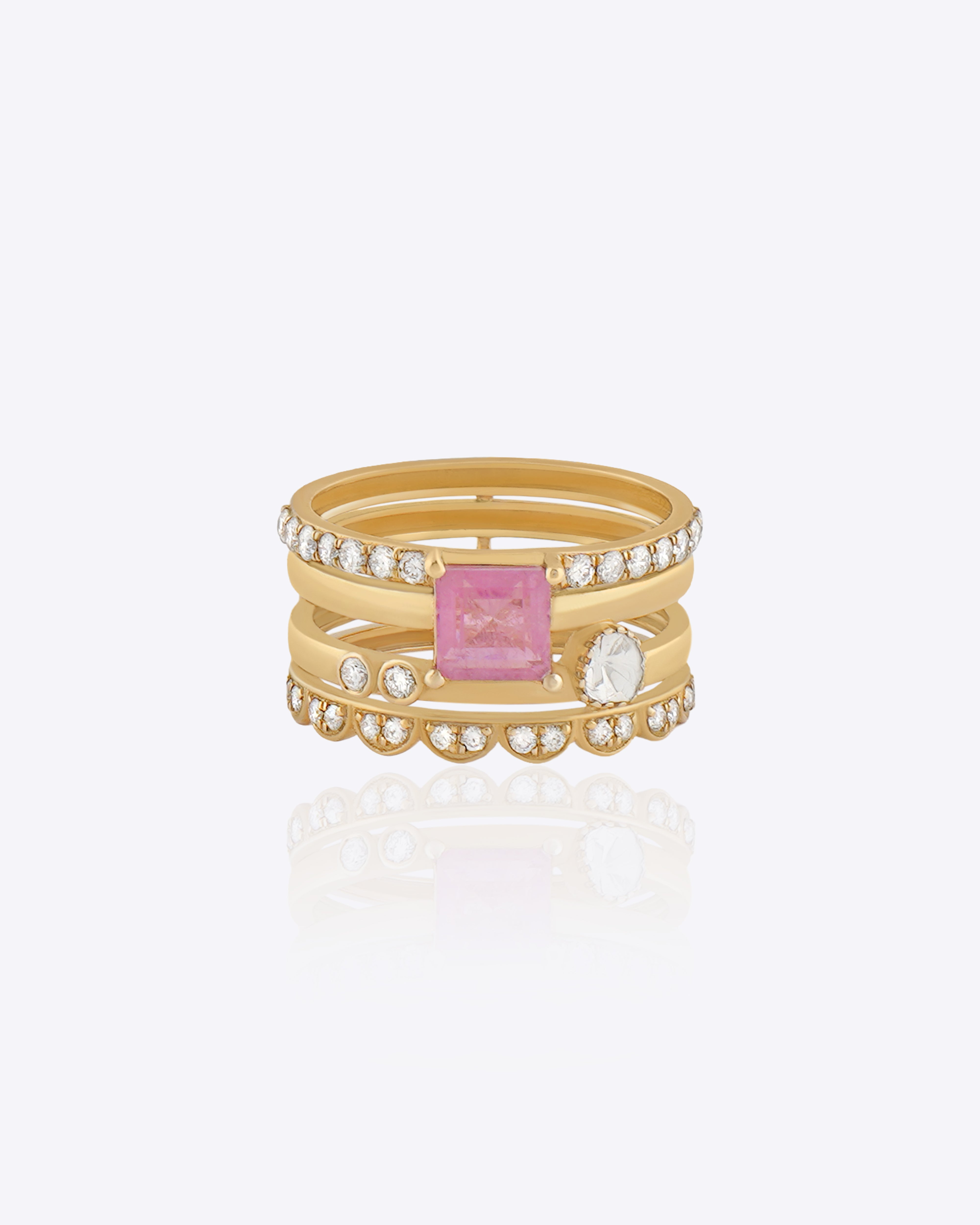 Featuring a multi-layered gold band with a pink center stone and Polki detailing.